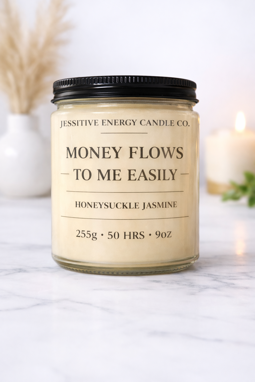 Candle jar with 'Money Flows to Me Easily' text on a marble surface
