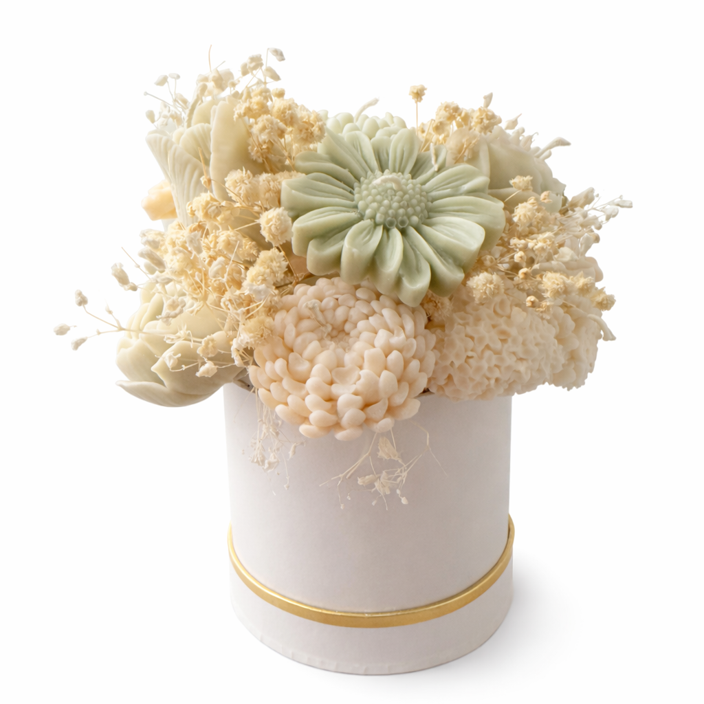 Decorative flower arrangement in a white container with gold accent on a white background