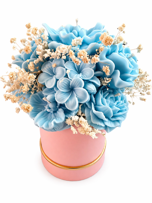 Handcrafted floral candle bouquet made with premium blended wax, featuring blue wax flowers arranged in a pink 4x4 base with dried floral accents.