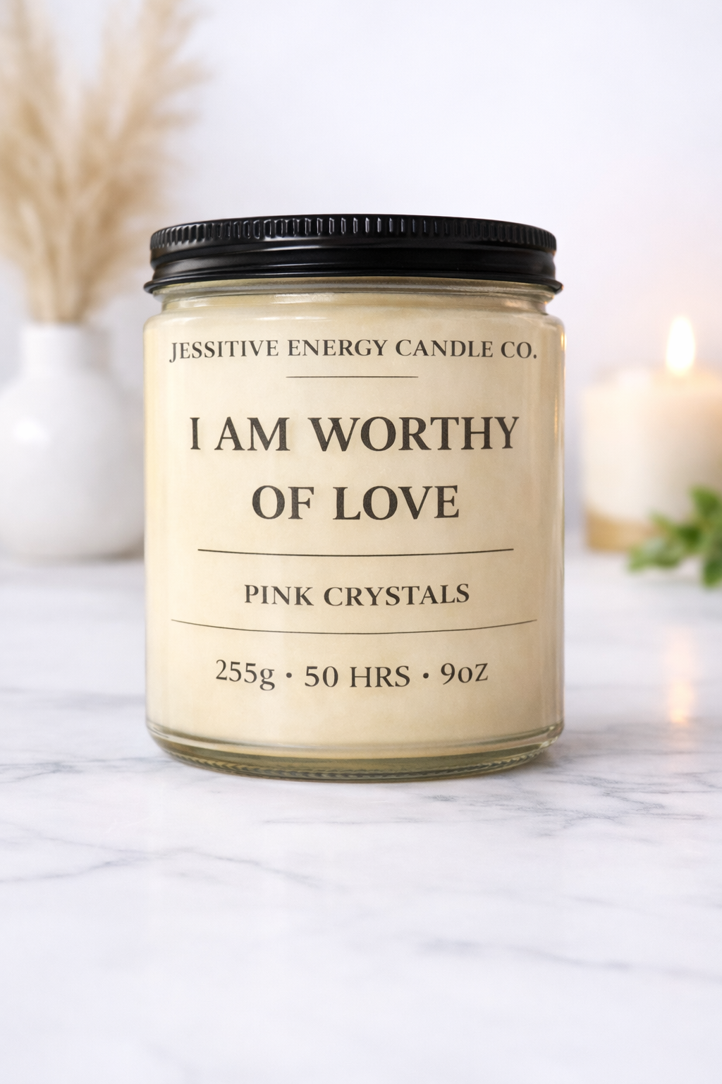 Candle jar with 'I AM WORTHY OF LOVE' text on a marble surface