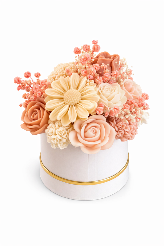 Decorative flower arrangement in a white box with gold trim on a white background