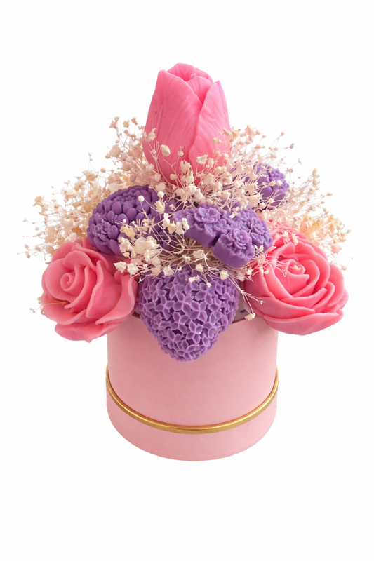 Pink and purple flower arrangement in a pink container on a white background